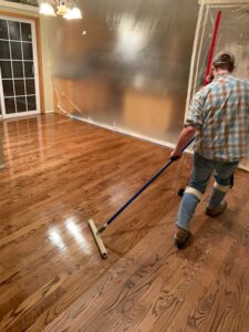 Our team adding a protective finish to hardwood floors