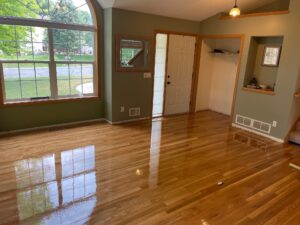 A beautiful, rich hardwood floor that reflects light from nearby windows