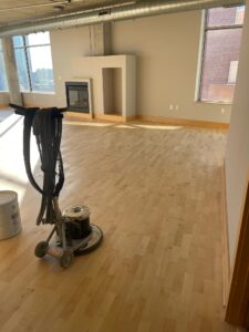 A buffer ready for use on light-brown hardwood floors