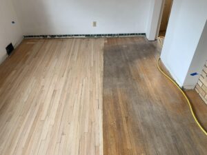 A hardwood floor in the process of being repaired, The left side looks great and the right side shows how the floor was in rough shape
