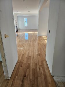 Light brown hardwood floors, freshly installed, shining in sunlight